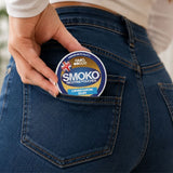 Woman putting a can of SMOKO Nicotine Pouches into her back pocket - Made in the UK